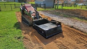 dingo stand on skid steer with rockaway landscaping rock rake attachment